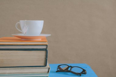 Kitap gözlük ve çay ile çalışma ve eğitim concep masaya
