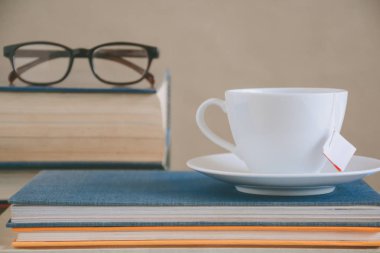 Kitap gözlük ve çay ile çalışma ve eğitim concep masaya