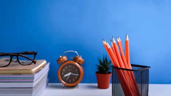 Boeken potlood en glazen op een witte houten tafel zijn klokken en — Stockfoto