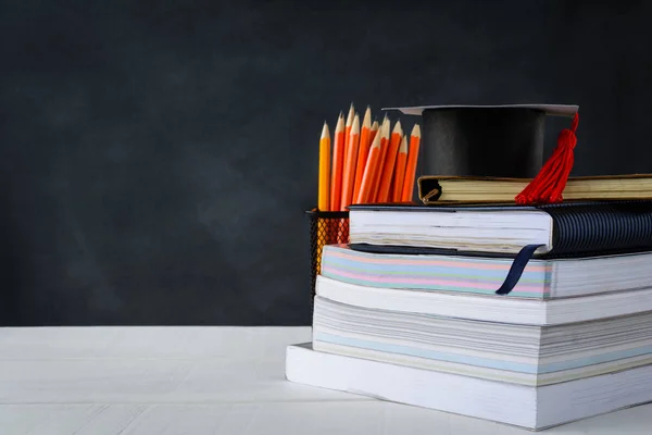 Book and pencil on white table black board background — Stock Photo, Image