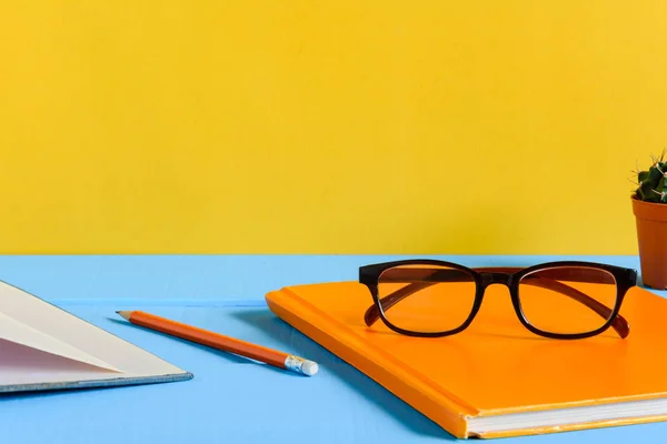 Libros Lápiz y vasos sobre una mesa de madera azul — Foto de Stock