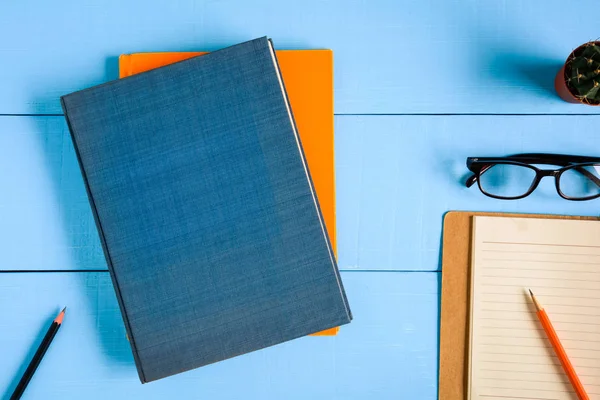 Üstten Görünüm kitap mockup ve kalem kayda göre mavi ahşap masa