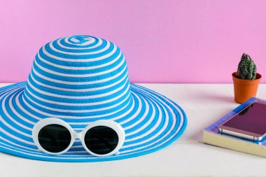 Mavi şapka ve beyaz güneş gözlüğü pembe duvar arka plan