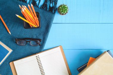 Üstten Görünüm defteri ve kalem kayda göre mavi ahşap masa