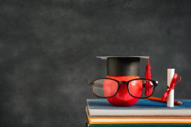 Elma bilgi sembolü ve masanın üstüne kalem kitap