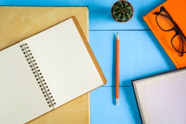 Üstten Görünüm kitap mockup ve kalem kayda göre mavi ahşap masa