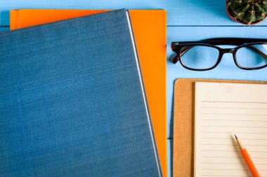 Üstten Görünüm kitap mockup ve kalem kayda göre mavi ahşap masa