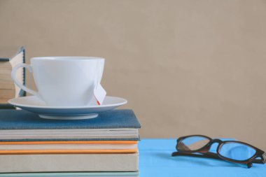 Kitap gözlük ve çay ile çalışma ve eğitim concep masaya