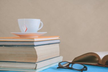 Kitap gözlük ve çay ile çalışma ve eğitim concep masaya