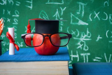 Elma bilgi sembolü ve masanın üstüne kalem kitap 