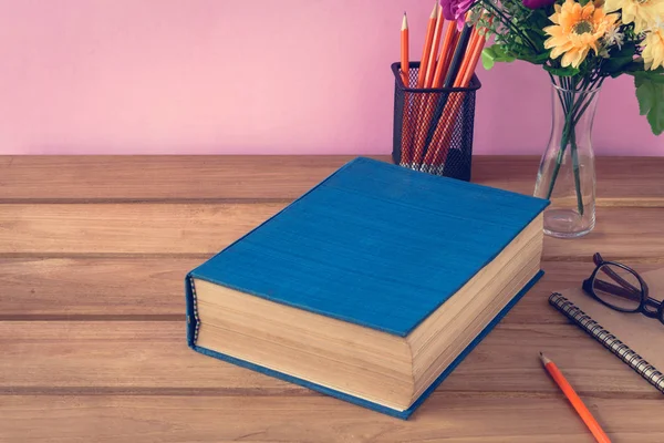 Boek en potlood nota over houten tafel — Stockfoto
