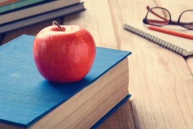 Kalem ve apple bir beyaz tahta masada kitaplar 