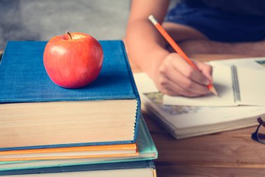 Kalem ve apple bir beyaz tahta masada kitaplar 