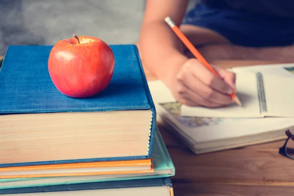 Böcker penna och apple på en vit trä bord — Stockfoto