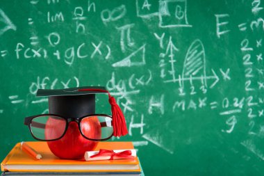 Elma bilgi sembolü ve masanın üstüne kalem kitap