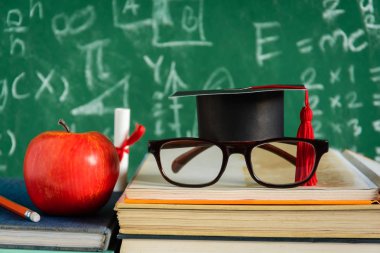 Elma bilgi sembolü ve masanın üstüne kalem kitap