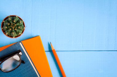 Üstten Görünüm kitap mockup ve kalem kayda göre mavi ahşap masa