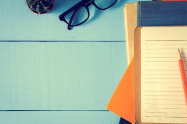 Üstten Görünüm kitap mockup ve kalem kayda göre mavi ahşap masa