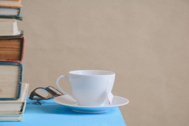 Kitap gözlük ve çay ile çalışma ve eğitim concep masaya