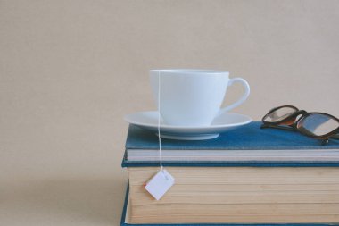 Kitap gözlük ve çay ile çalışma ve eğitim concep masaya