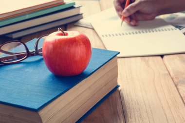 Kalem ve apple bir beyaz tahta masada kitaplar 