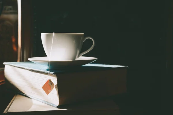 Bok och te på skrivbordet med studie — Stockfoto