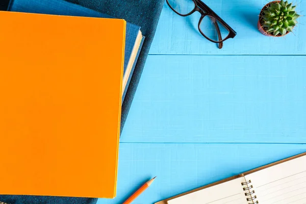 Libro de vista superior y lápiz nota sobre tabla de madera azul — Foto de Stock