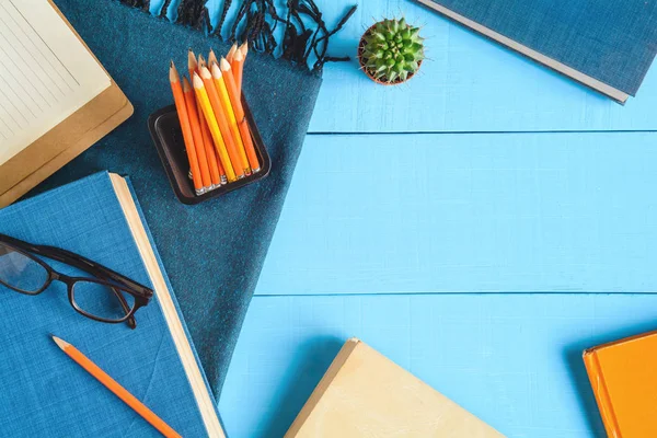 Книга зверху та олівець на синьому дерев'яному столі — стокове фото