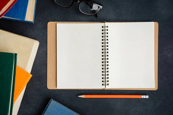 Boka glasögon och penna på skrivbordet — Stockfoto