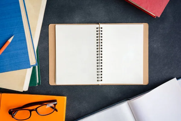 Boka glasögon och penna på skrivbordet — Stockfoto