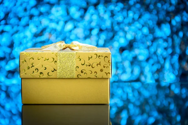 Gifts and toys on glass table and bokeh blue light background — Stock Photo, Image