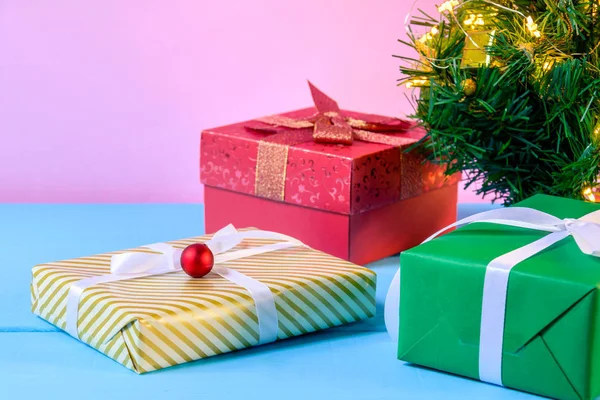 Geschenkboxen auf Holz Schreibtisch rosa Wand Hintergrund — Stockfoto