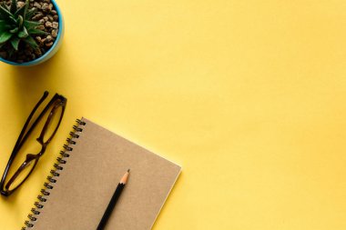 defter ve kalem sarı masa üzerinde
