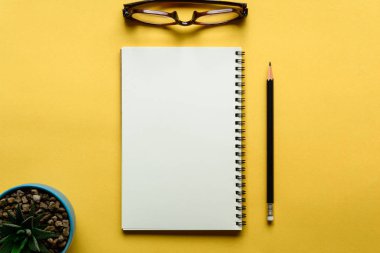 defter ve kalem sarı masa üzerinde