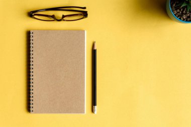 defter ve kalem sarı masa üzerinde