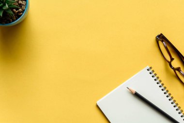 defter ve kalem sarı masa üzerinde