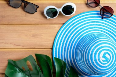 Üstten Görünüm mavi şapka ve güneş gözlüğü ahşap bir masa üzerinde 