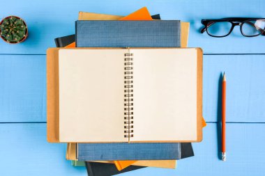 Üstten Görünüm kitap mockup ve kalem kayda göre mavi ahşap masa