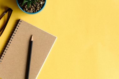 defter ve kalem sarı masa üzerinde