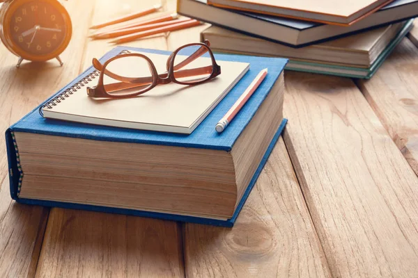 Книги та окуляри на дерев'яному столі — стокове фото
