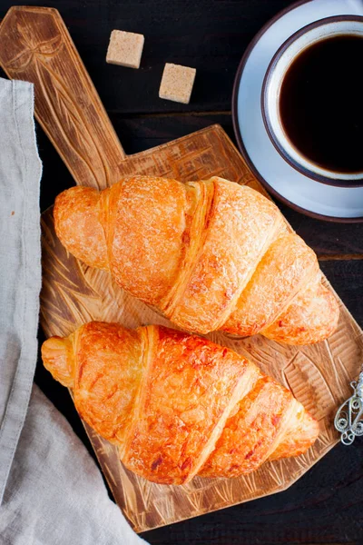 Croissants und Kaffee auf dunklem Hintergrund, Draufsicht. — Stockfoto