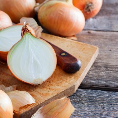 Vintage soğan ahşap bir masa üzerinde bir kurulu, vitaminler, yatay, kopya alanı kesilmiş soğan ile