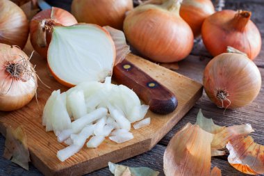 Tüm ampuller ve kabuğu yatay bir tahta masada yanında ince kıyılmış soğan