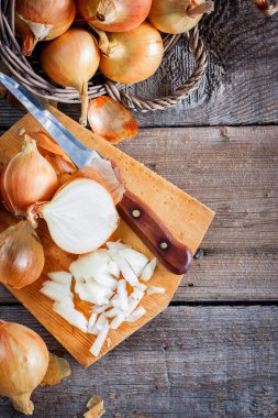 Bir büyük soğan ürün bir hasır sepet içinde. Soğan vitaminler, baharda yararlı zengindir. Soğan bir ahşap arka plan karşı soyulmuş. Üstten Görünüm, seçici odak