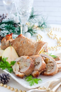 Domuz eti ve armut beyaz bir tabak içinde Noel süsleri, seçici odak üzerinde rulo