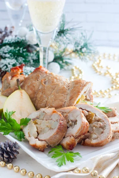 Domuz eti ve armut beyaz bir tabak içinde Noel süsleri, seçici odak üzerinde rulo