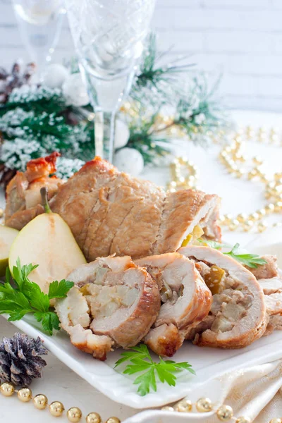 Ролик свинины и груш на белом блюде в рождественских украшениях, избирательный фокус — стоковое фото