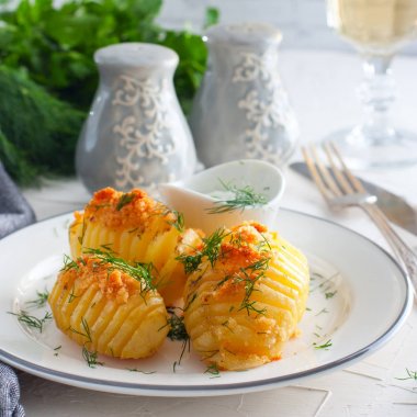 Taze dereotu soslu, kare beyaz tabakta fırında patates 