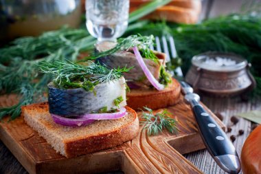 Soğan, seçici odak ile siyah ekmek üzerinde dereotu ile marine edilmiş ringa balığı