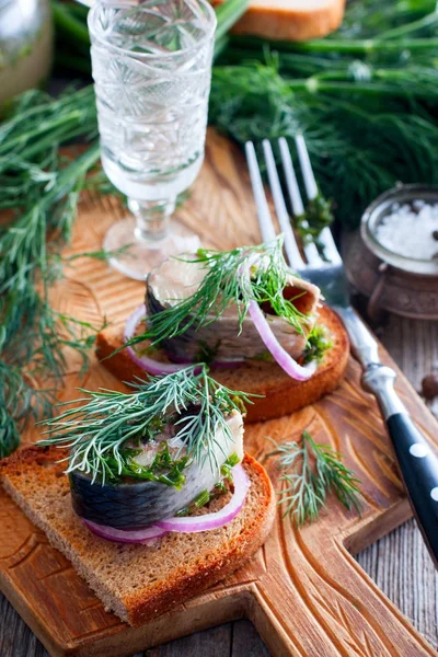 Marinated herring with dill on black bread with onion, selective focus — Stock Photo, Image